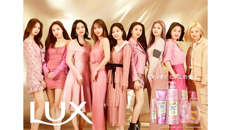  TWICEメンバー９人がピンク系の洋服を着て横並びに立ってポーズを取っている姿とLUX商品