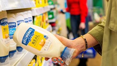 A shopper holding a bottle of Hellmann’s mayonnaise. Hellmann’s sits within Unilever’s Nutrition business group.