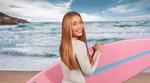 A girl holding a surf board on the beach