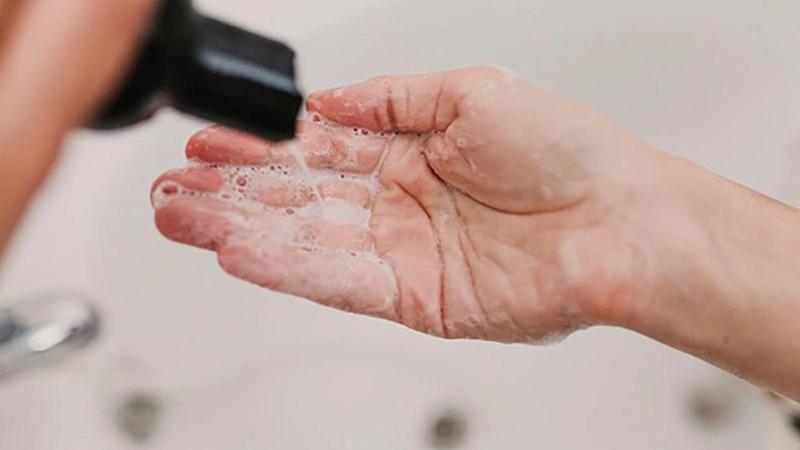 Mão com shampoo aplicado