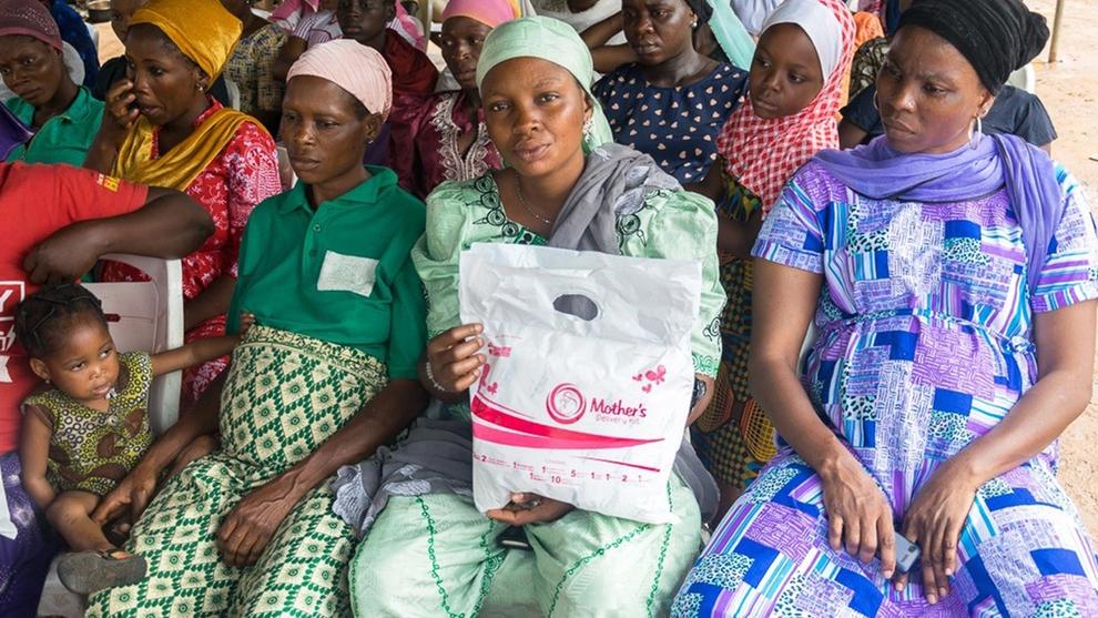 Adepuja Jaiyeoba with a Mother's Delivery Kit sitting among a group of pregnant women