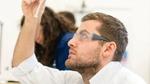 Scientist looking at a sample in a test tube