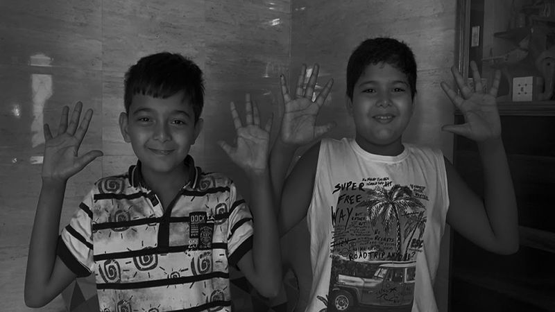 Two boys holding up their hands and smiling