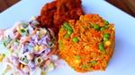 Plate of Jollof rice accompanied by two side dishes.