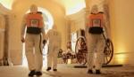 Three cleaners wearing protective clothing and carrying Lysoform spray backpacks in one of Italy’s main museums.