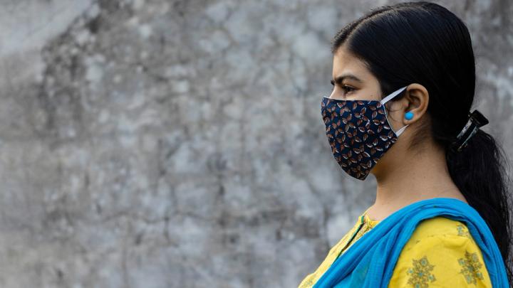 Side Face of an Indian woman wearing homemade cotton nose mask to reduce the spread of Covid-19 – stock photo