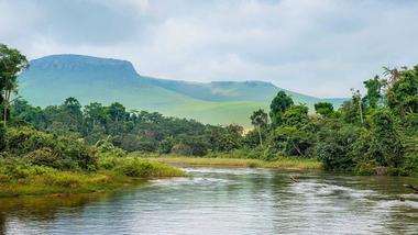 Congo river with mountains in the background and trees on the banks
