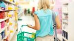 A woman walking up a supermarket aisle