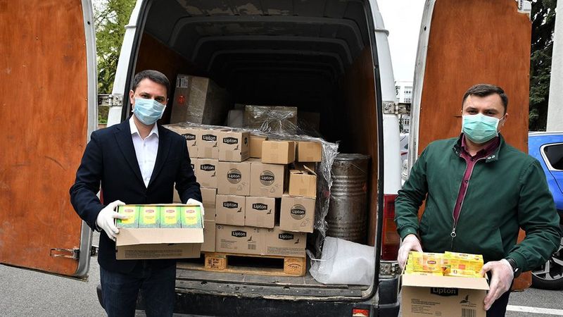 Unilever products, donated to a hospital, being unloaded from a van by two men wearing surgical masks