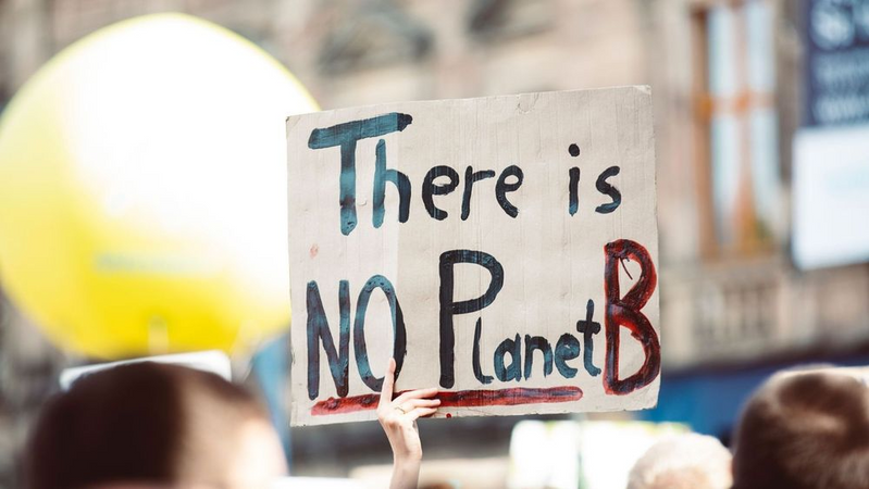 Image shows a sign saying ‘There Is No Planet B’