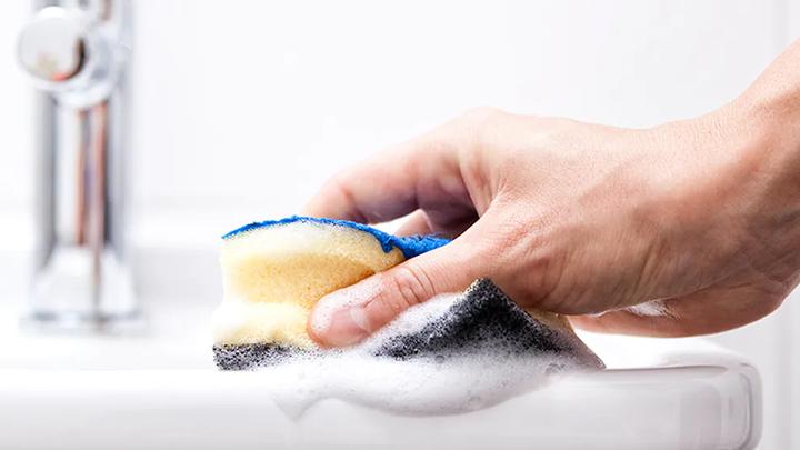 Person cleaning basin with sponge. A Domestos campaign educated people on the importance of safe cleaning with bleach.