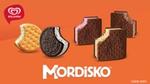 En un fondo naranja se aprecian los 5 mordiskos que tiene la marca (Pay de Limón, Mordisko Oreo, Mordisko Clásico, Mordisko Fresa, Mordisko Chocolate)