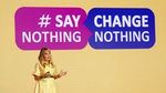 Aline Santos standing on a stage with a background sign with the words ‘Say Nothing, Change Nothing’