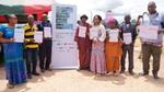 Group of eight smallholder cocoa farmers holding up their land tenure documents at a presentation ceremony.