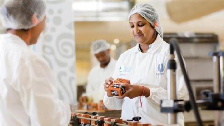 Image of a female HUL employee working at a HUL facility. She appears to be smiling. 
