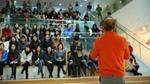 Man with red shirt lecturing to students