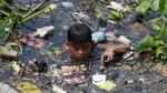 A boy wades through a chronically polluted waterway in the Philippines. Image: Reuters