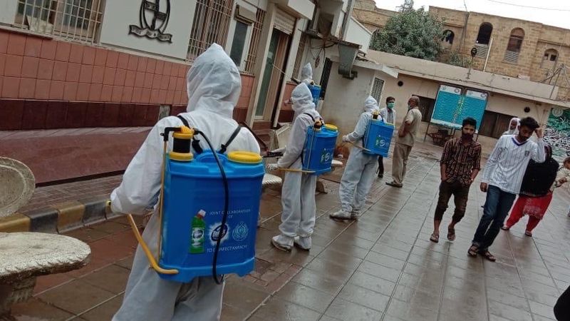 Photo of people disinfecting a street