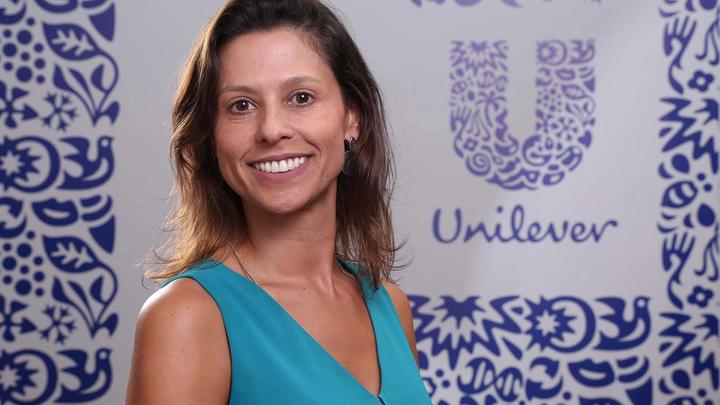 Unilever Hero Juliana Abreu, smiling, with Unilever-branded background