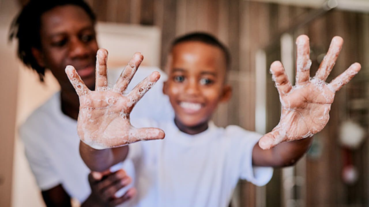 A child showing soap on his hands