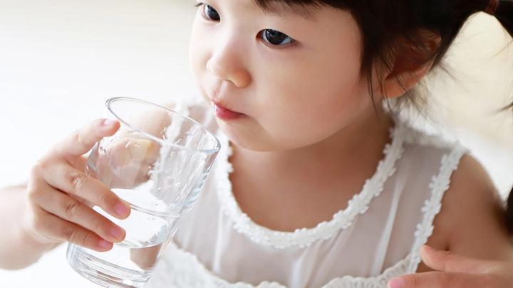 A child drinking a glass of water