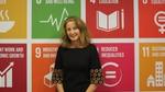 Marcela Manubens with the United nations' sustainable development goals behind