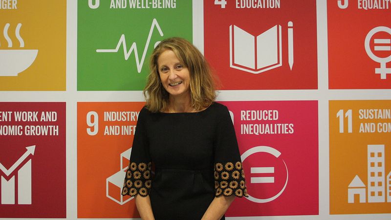 Marcela Manubens with UN's SDGs on her background