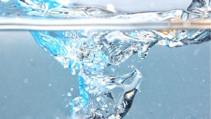 Close-up image of water splashing into a glass