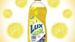 Reclame voor een fles Lux handafwasmiddel met een achtergrondpatroon van schijfjes citroen.