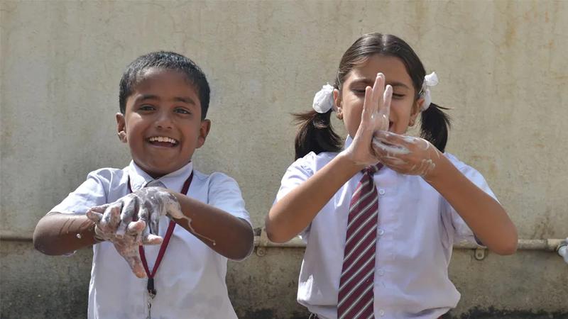 Two children washing their hands