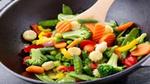 Wok pan with variety of colorful vegetables being stirred
