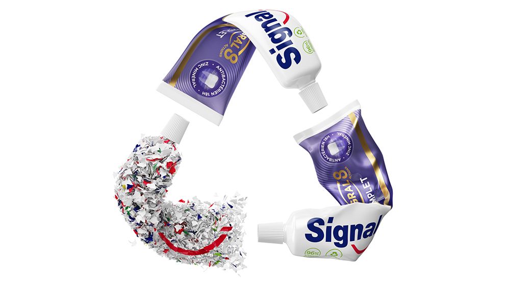 Three Signal toothpaste tubes forming shape of recycling logo.