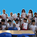 School children smiling and holding up certificates from completing happiness lessons from Wall’s and The Happiness Project