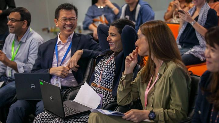 A photograph of a group of Unilever employees laughing together in a conference room