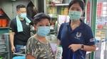 Three people wearing masks in a commercial kitchen with Unilever employee giving a bottle of Cif to the owner.