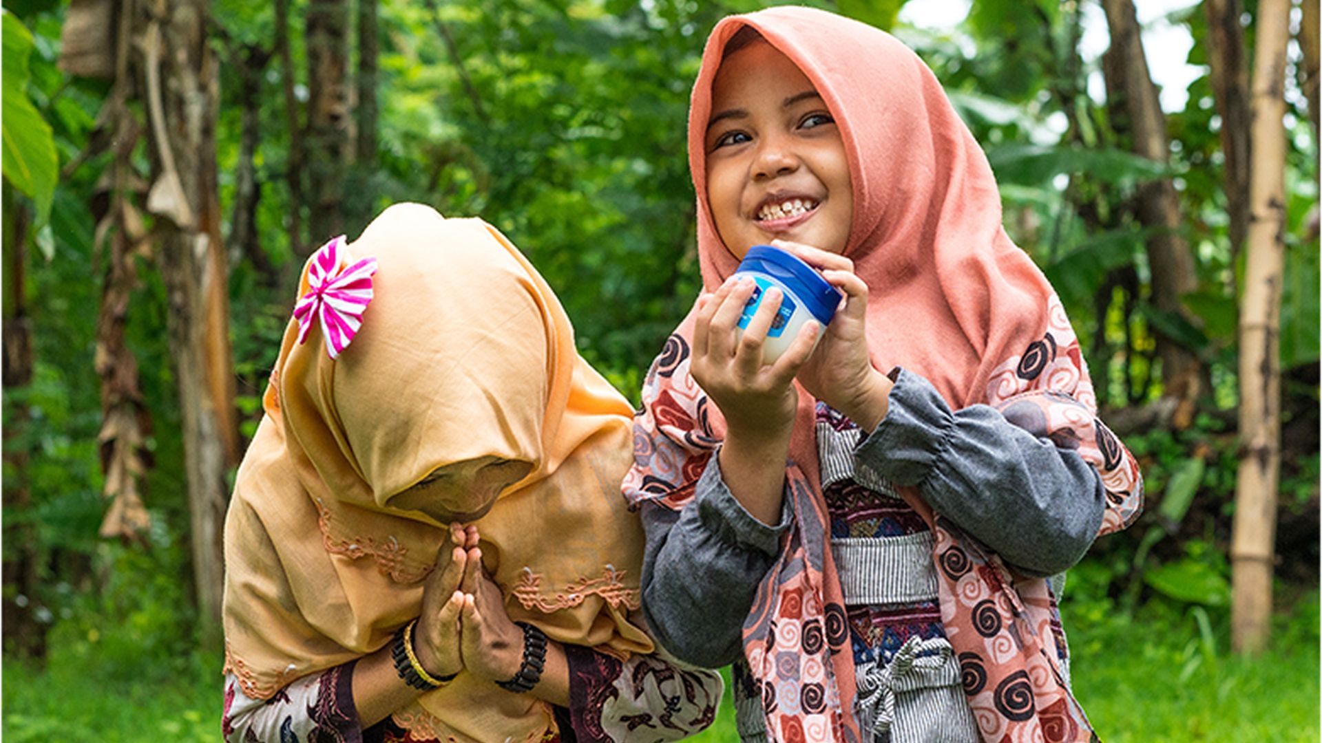 Young girls playing in front of trees