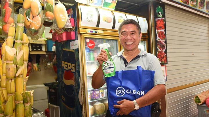 Man happily holding a cif spray bottle