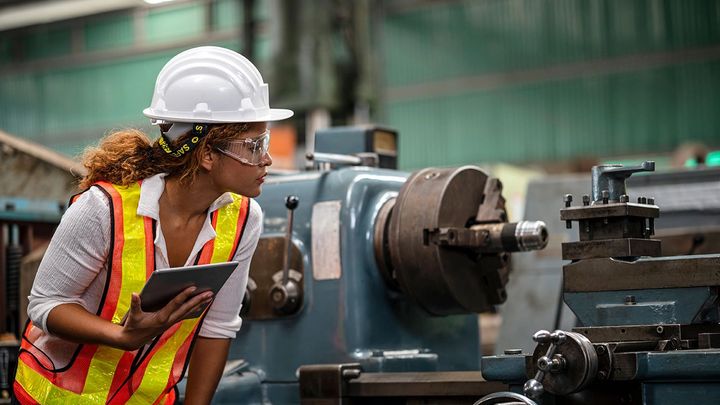 Factory worker assessing a machine