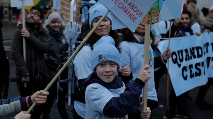 Boy holding placard protesting about climate change