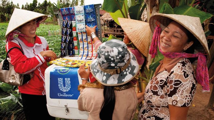Women by a Market stall in Asia displaying Unilever products