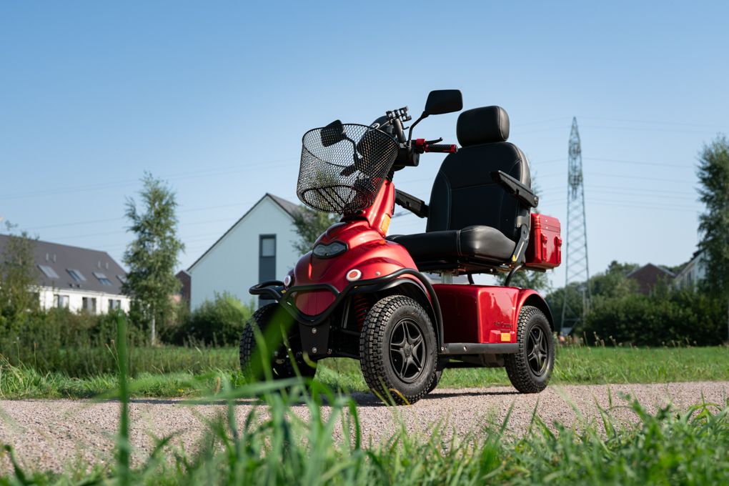Senior fährt Elektromobil über einen Landweg