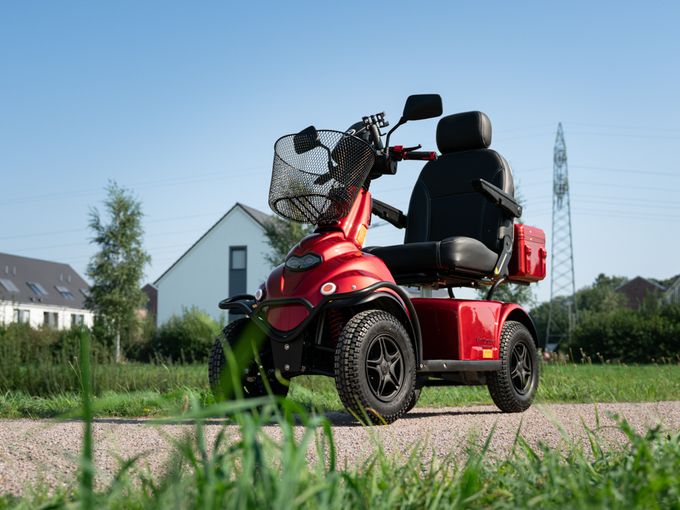 Senior fährt Elektromobil über einen Landweg