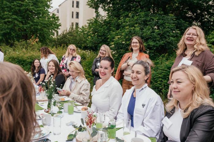 WECODA members smiling around a garden table