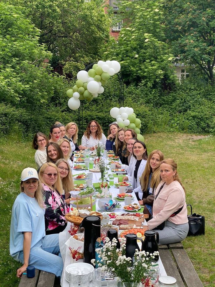 WECODA members seated at a long outdoor table