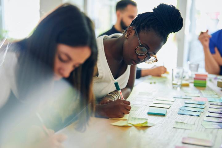 Crew members jotting down ideas on sticky notes
