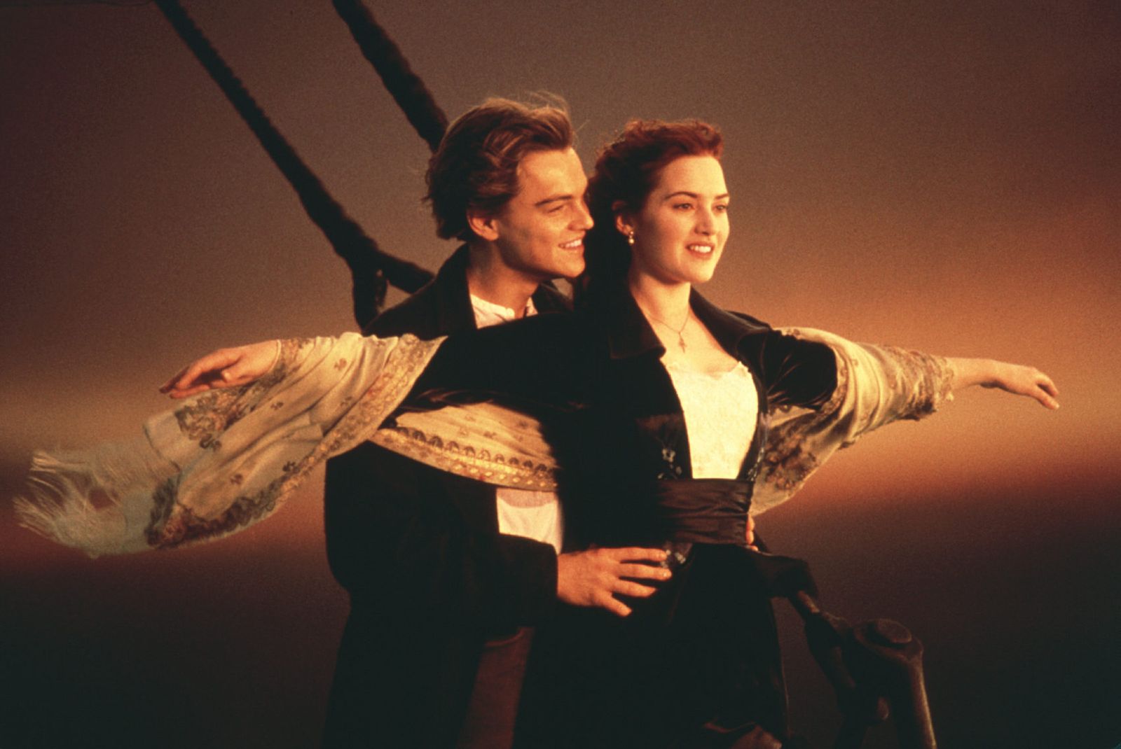 Jack and Rose standing aboard the deck of the Titanic looking out towards the ocean. Rose has her arms outstretched