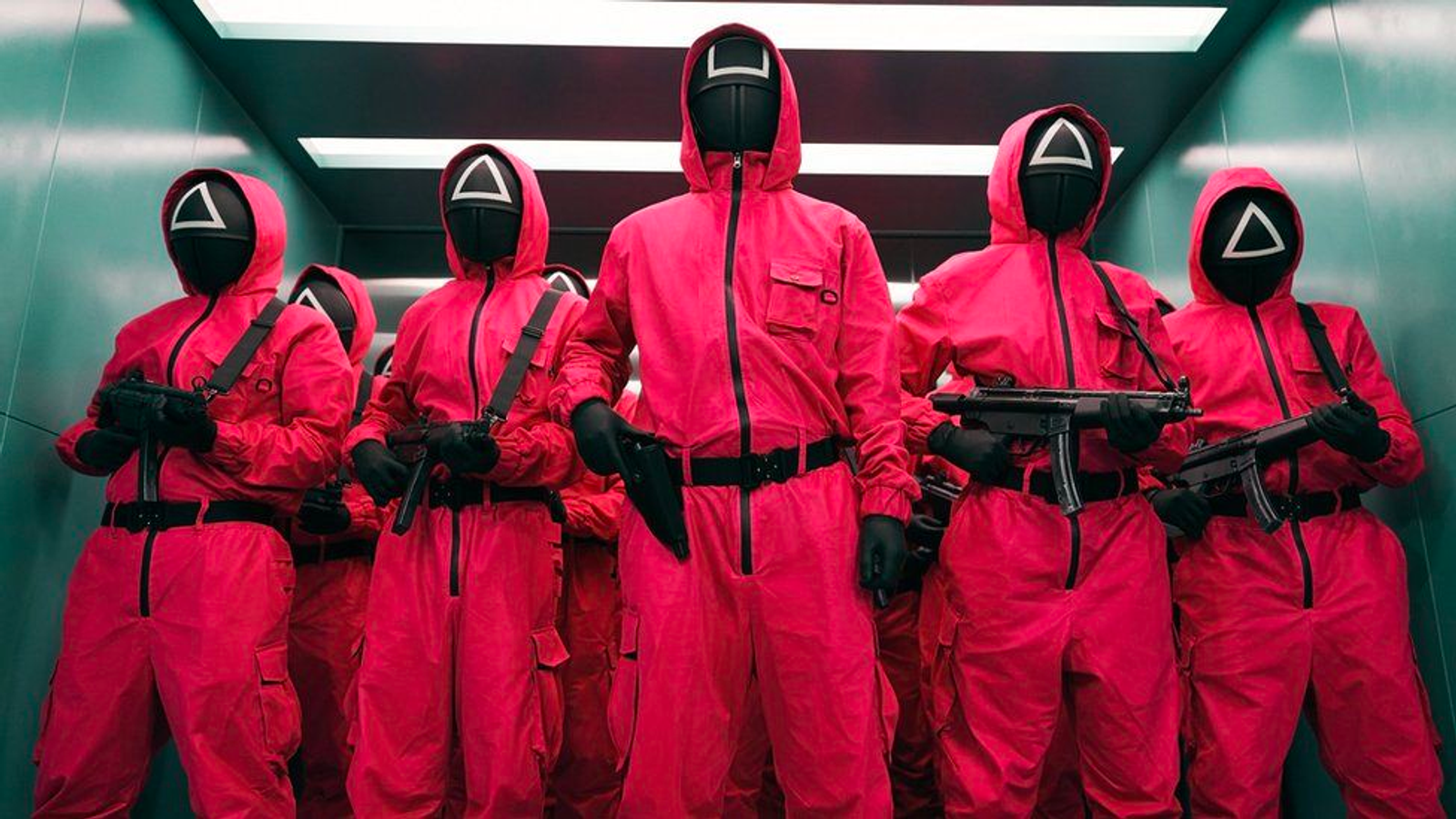 The guards that coordinate the games are dressed in pink suits and don masks resembling video game symbols.