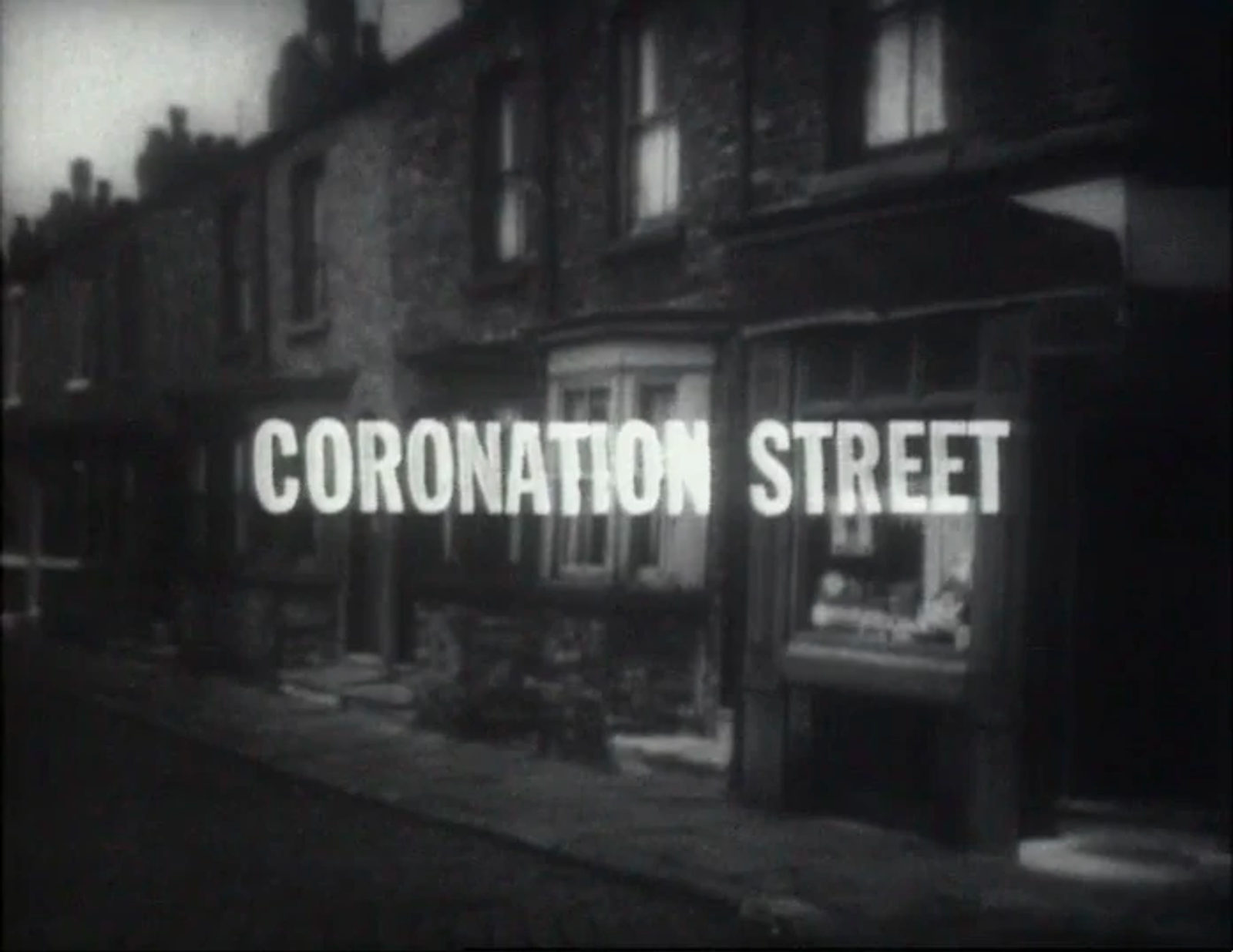 The original black and white title card of Coronation Street, the longest running soap opera in history. It depicts a suburban street in the North of England with pay windows and the all caps words Coronation Street