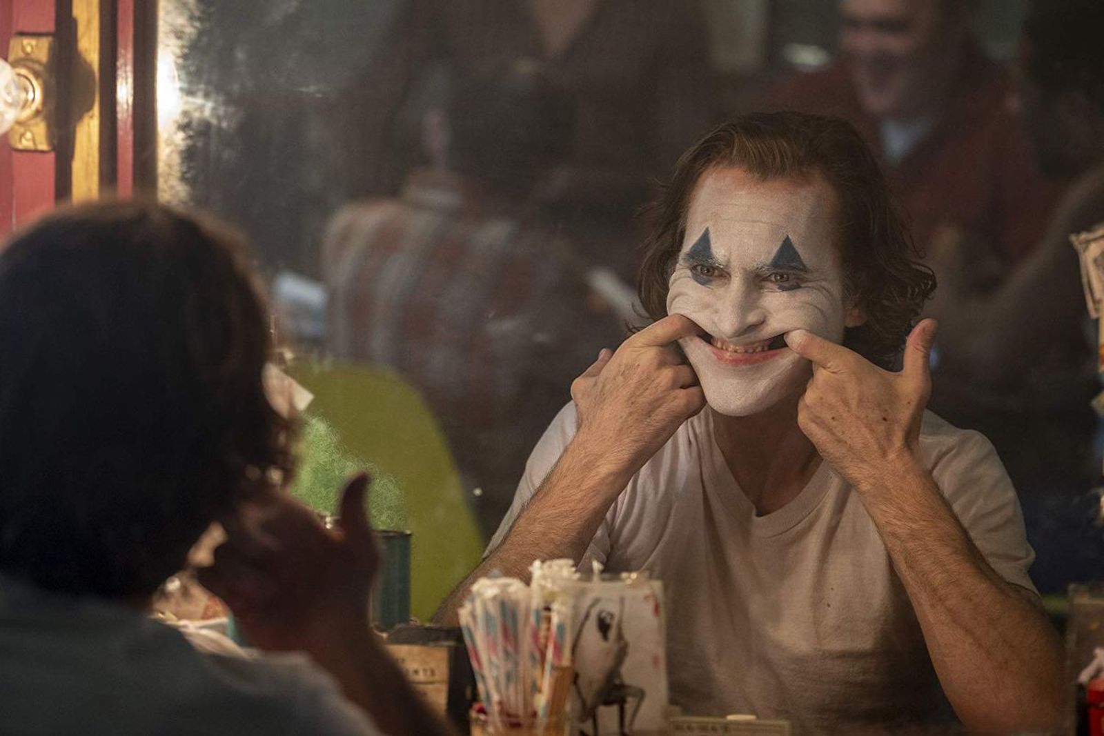 The Joker pulls his face into a smile.