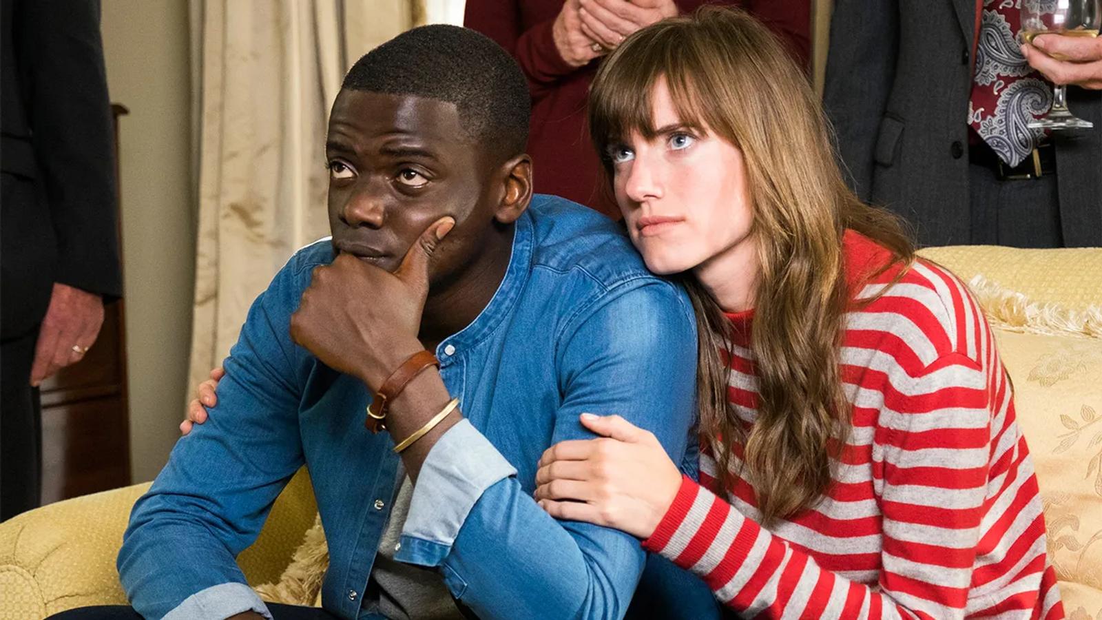 Chris (Daniel Kaluuya) and Rose (Allison Williams) sitting on her parent's couch.